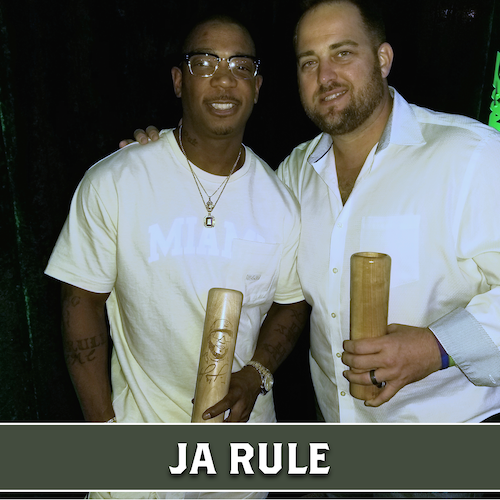 Ja Rule posing  holding  a wooden Dugout Mugs baseball bat mugs