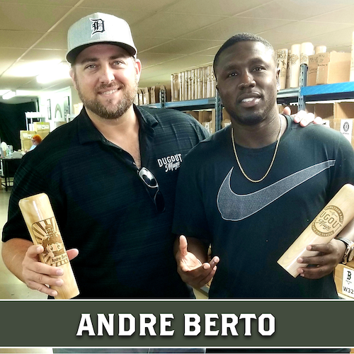 Andre Berto posing beside a Dugout Mugs team member, both holding wooden baseball bat mugs.
